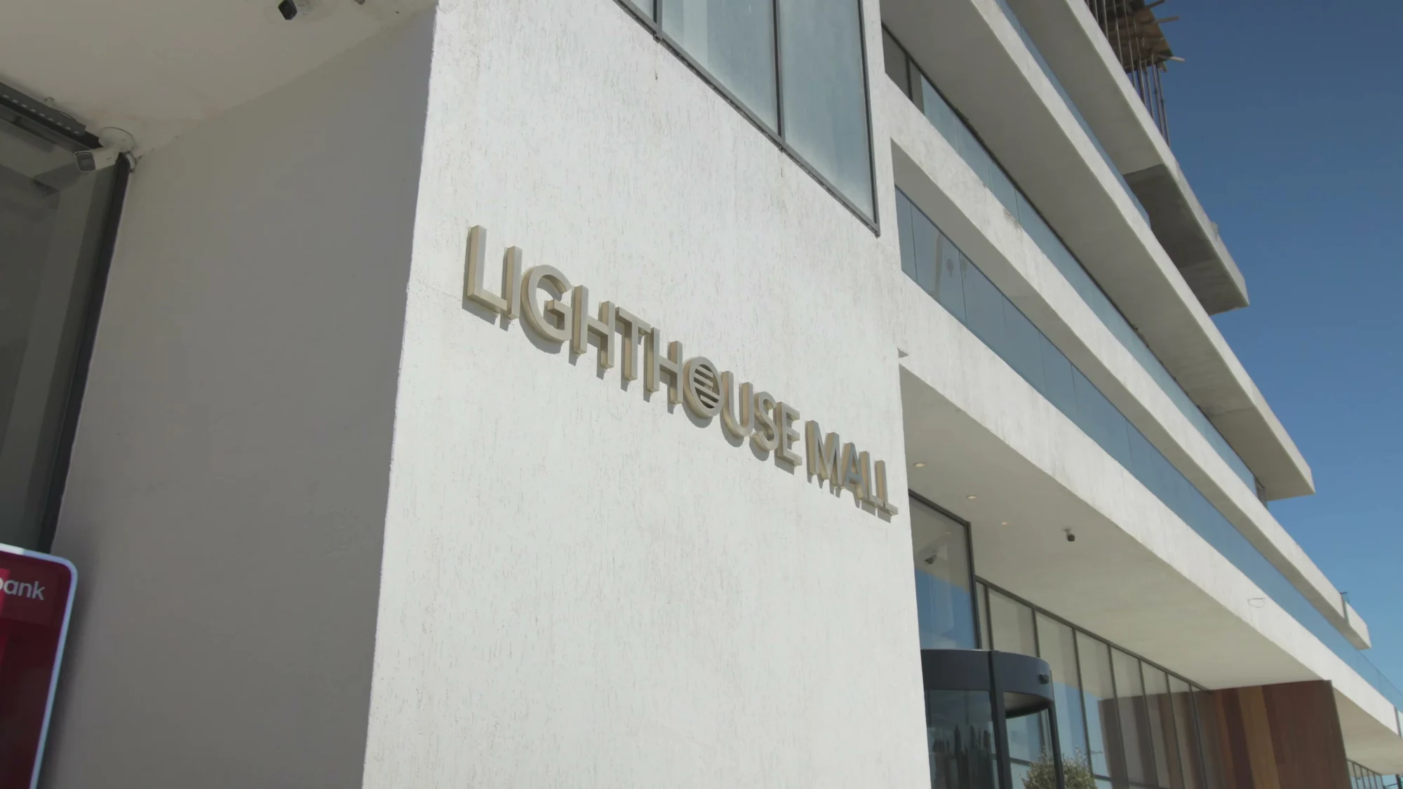 Вывеска Lighthouse Mall на белом фасаде — İrşad на втором этаже этого здания